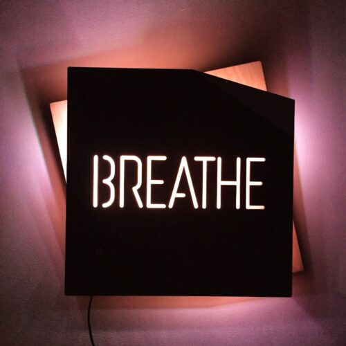 BREATHE - REBELlamps.com wooden LED sign with pink light on